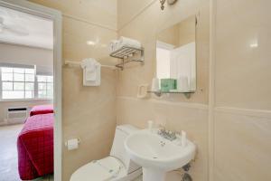 ein Badezimmer mit Waschbecken, Toilette und Spiegel in der Unterkunft James Hotel in Miami Beach