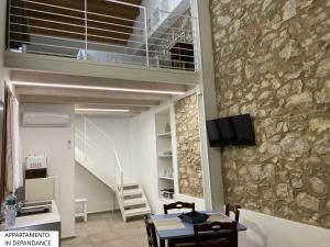 a room with a stone wall and a table and chairs at Tenute Plaia Agriturismo in Scopello