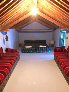 an attic room with red and blue couches at Dar Dadicilef in Chefchaouene