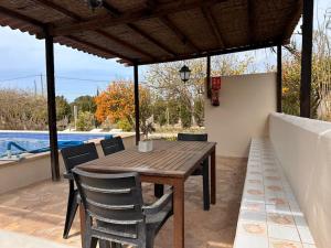 a wooden table and chairs on a patio with a pool at Casa Clot III- Formentera in Illes Balears +7 photos