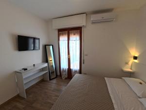 a bedroom with a bed and a tv on the wall at Sunrise Bed and Breakfast in Peschici