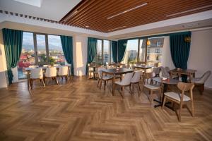 a restaurant with tables and chairs and large windows at Crown Hotel in Bishkek