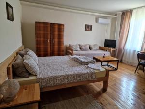 a living room with a bed and a couch at Konak -Guest house -Ramonda Serbika in Niš