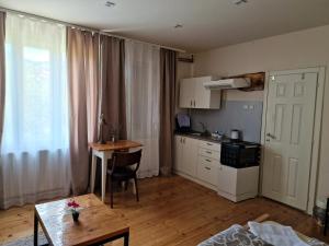 a living room with a table and a kitchen with a tableablish at Konak -Guest house -Ramonda Serbika in Niš