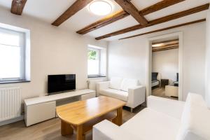 a living room with white furniture and a wooden table at Große Wohnung zu mieten im schönen Sulzheim Wörrstadt in Sulzheim
