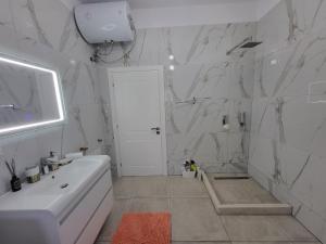 a white bathroom with a white tub and a sink at Villa Ndoni in Berat +22 photos