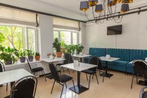 a restaurant with tables and chairs and a blue couch at Ajour in Almaty