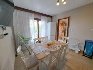 a dining room with a table and chairs and a kitchen at CASA Di TRE MARE in Nea Kallikrateia