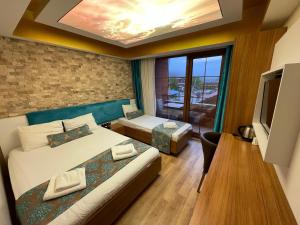 a hotel room with two beds and a television at Centro Park Hotel in Uzungöl