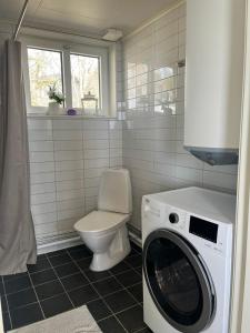 a bathroom with a washing machine and a toilet at Sjöstugan in Mariestad