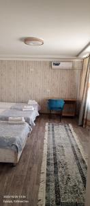 1 dormitorio con 2 camas y alfombra en Hotel Guest House GOLDEN DEGREZ en Bukhara