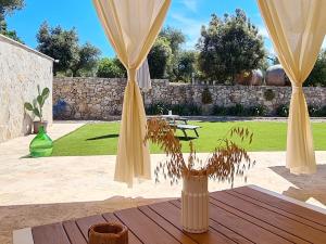 a vase with a plant sitting on a wooden table at Come una volta - Il Trullo in Alberobello