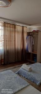 - une chambre avec un lit et une commode avec une chemise dans l'établissement Hotel Guest House GOLDEN DEGREZ, à Boukhara