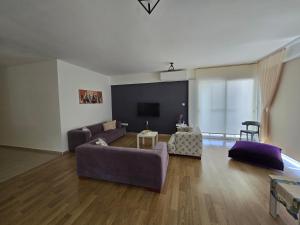 a living room with a couch and a flat screen tv at Lake View Apartment in Famagusta in Mağusa