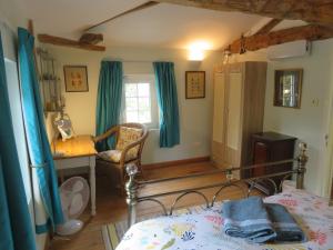 una camera da letto con un letto, una scrivania e una finestra di La Maison de Riviere a Bourg-Charente Altre 75 foto