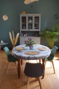 una sala da pranzo con tavolo e sedie di Le Cocon Asprion a Aspres-lès-Corps