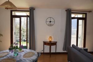 un soggiorno con un tavolo e un divano di Le Cocon Asprion a Aspres-lès-Corps