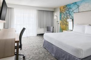 a hotel room with a large bed and a desk at Courtyard by Marriott Orlando Lake Buena Vista at Vista Centre in Orlando