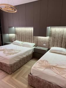 two beds in a bedroom with purple walls at Sun Holiday Apartment in Lezhë