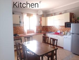 a kitchen with a table and chairs and a refrigerator at Leos Villa in Tragjas