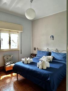 a bedroom with a blue bed with towels on it at Villa bianca in Piediluco