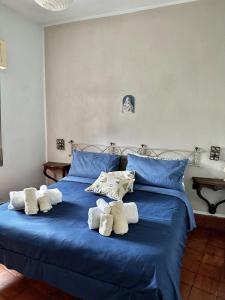 a bed with blue sheets and white towels on it at Villa bianca in Piediluco