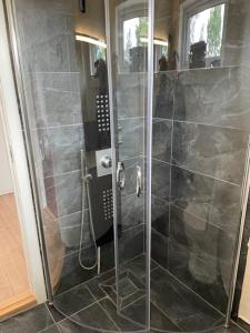 a shower with a glass door in a bathroom at Coasthouse ved havet in Hadsund +13 photos