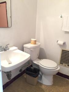 uma casa de banho com um WC branco e um lavatório. em Holiday Lodge em Los Angeles