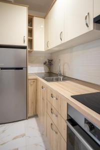 a kitchen with wooden cabinets and a stainless steel refrigerator at Apartment Iva in Vrana