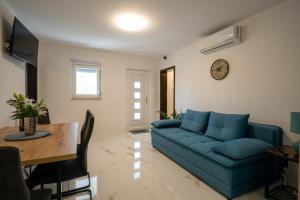 a living room with a blue couch and a table at Apartment Iva in Vrana