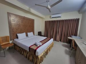 a bedroom with a large bed in front of a window at Cox West Inn in Cox's Bazar
