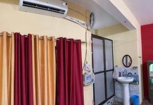 baño con cortina de ducha roja y lavamanos en Anushttha Home Stay, en Faizābād