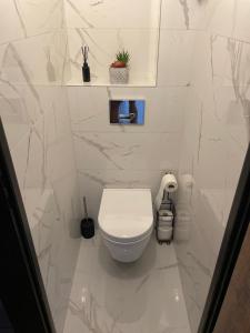 bagno bianco con servizi igienici e pianta di mieszkanie na osiedlu siedemsetlecia a Uniejow