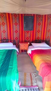two beds in a room with colorful walls at Merzouga wild Camp in Merzouga