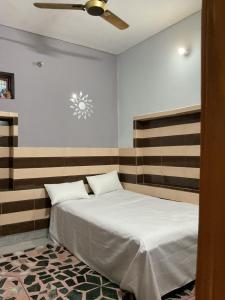 Un dormitorio con una cama y un ventilador de techo. en Anushttha Home Stay, en Faizābād 30 fotos más