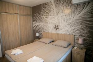 a bedroom with a bed with a flower mural on the wall at VARNA SEA VIEW Apartment in Varna City