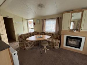 a living room with a table and a couch at Goodwin's static caravan in Mablethorpe