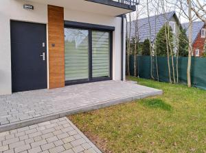 una casa con una porta blu e un cortile erboso di Apartament Jastrzębinka a Jastrzębia Góra