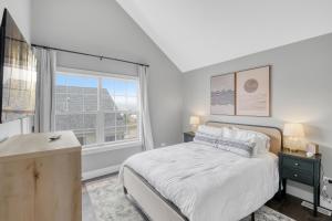 a white bedroom with a bed and a window at A Touch of Grey in Ottawa +33 photos