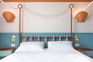 um quarto com uma cama de dossel com lençóis brancos em Murè Hotel Numana em Numana