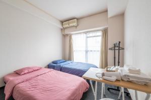 Postel nebo postele na pokoji v ubytování アストロヴィラ松屋町702号室