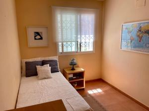 ein kleines Schlafzimmer mit einem Bett und einem Fenster in der Unterkunft Agradable adosado con piscina y jardín in Canet d'en Berenguer + 16 Fotos