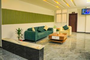 un soggiorno con divano verde e tavolo di Messay Hotel ad Addis Abeba