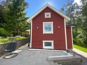 una casa roja con una silla delante en Charming apartment in a red house in Stockholm, en Estocolmo