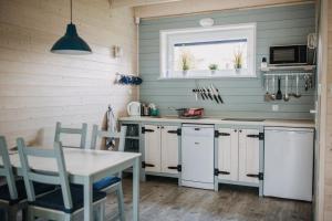 a kitchen with a table and a white refrigerator at Fajne Miejsce Dębki in Dębki