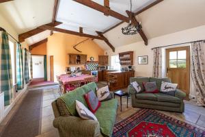 a living room with two couches and a kitchen at Swallows’ Barn in Durham