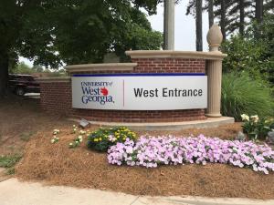 卡罗尔顿Super Inn & Suites Carrollton,West Georgia的西区入口的鲜花标志