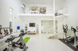 a gym with treadmills and exercise bikes in a room at Casa Veintiuno in Sosúa