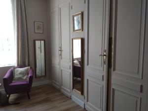 a room with a mirror and a purple chair at L'Acacia in Bergerac
