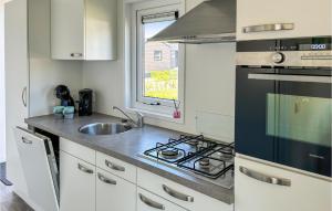 ScherpenisseにあるVakantiepark De Zeeuwse Parelのシンクとコンロのあるキッチン トップオーブン